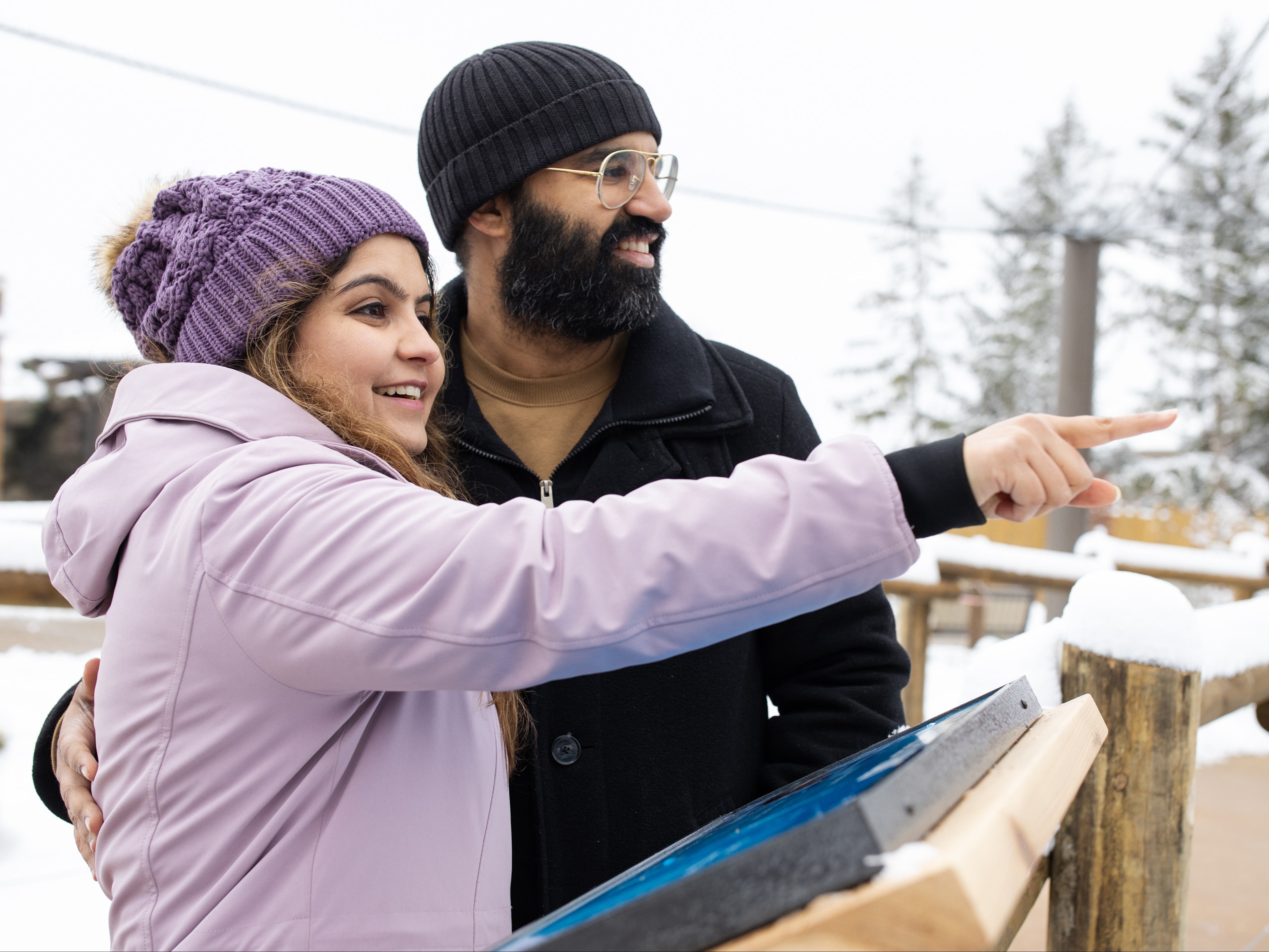 girl pointing into zoo habitat