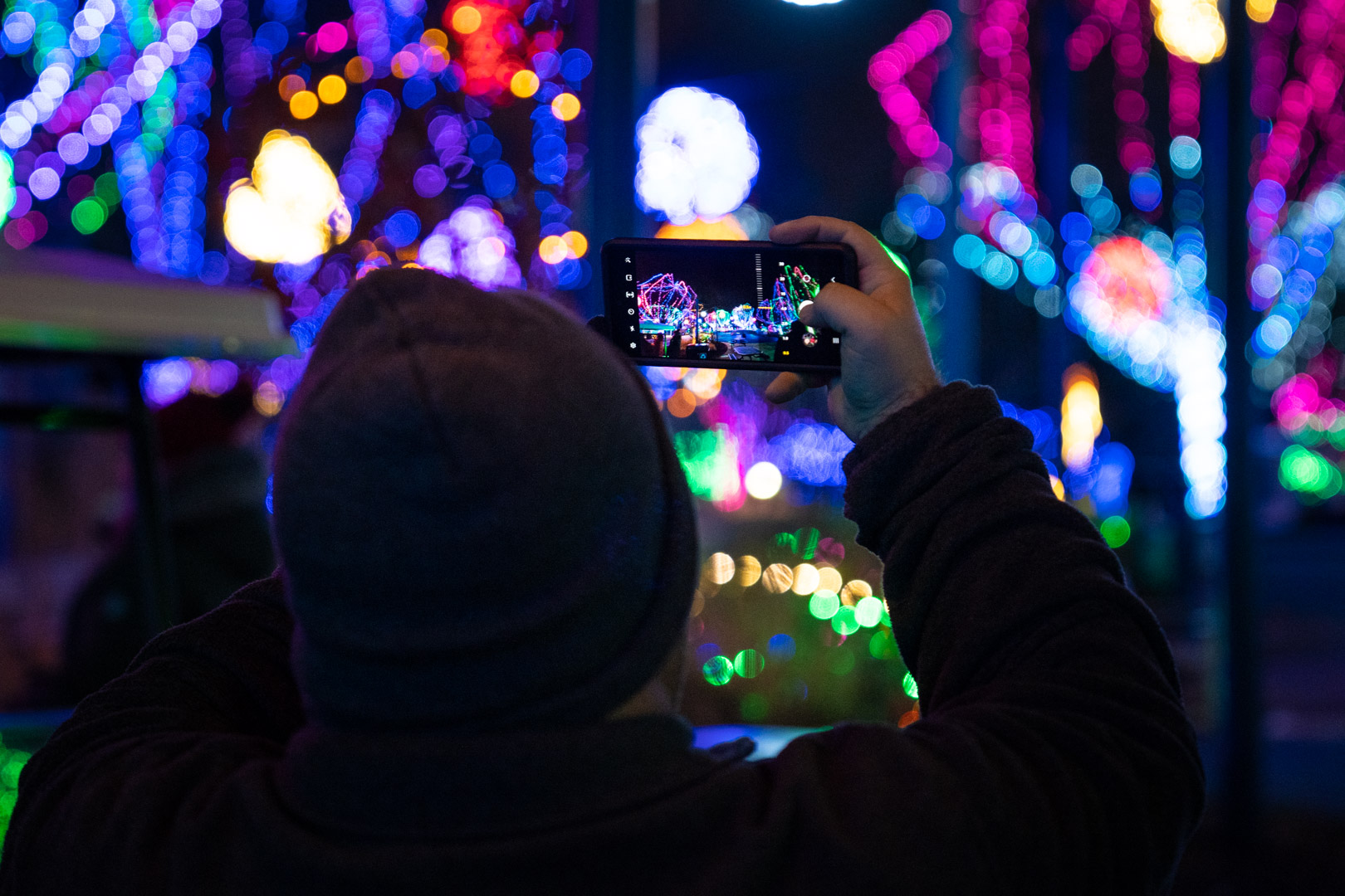 man taking photo of holiday lights