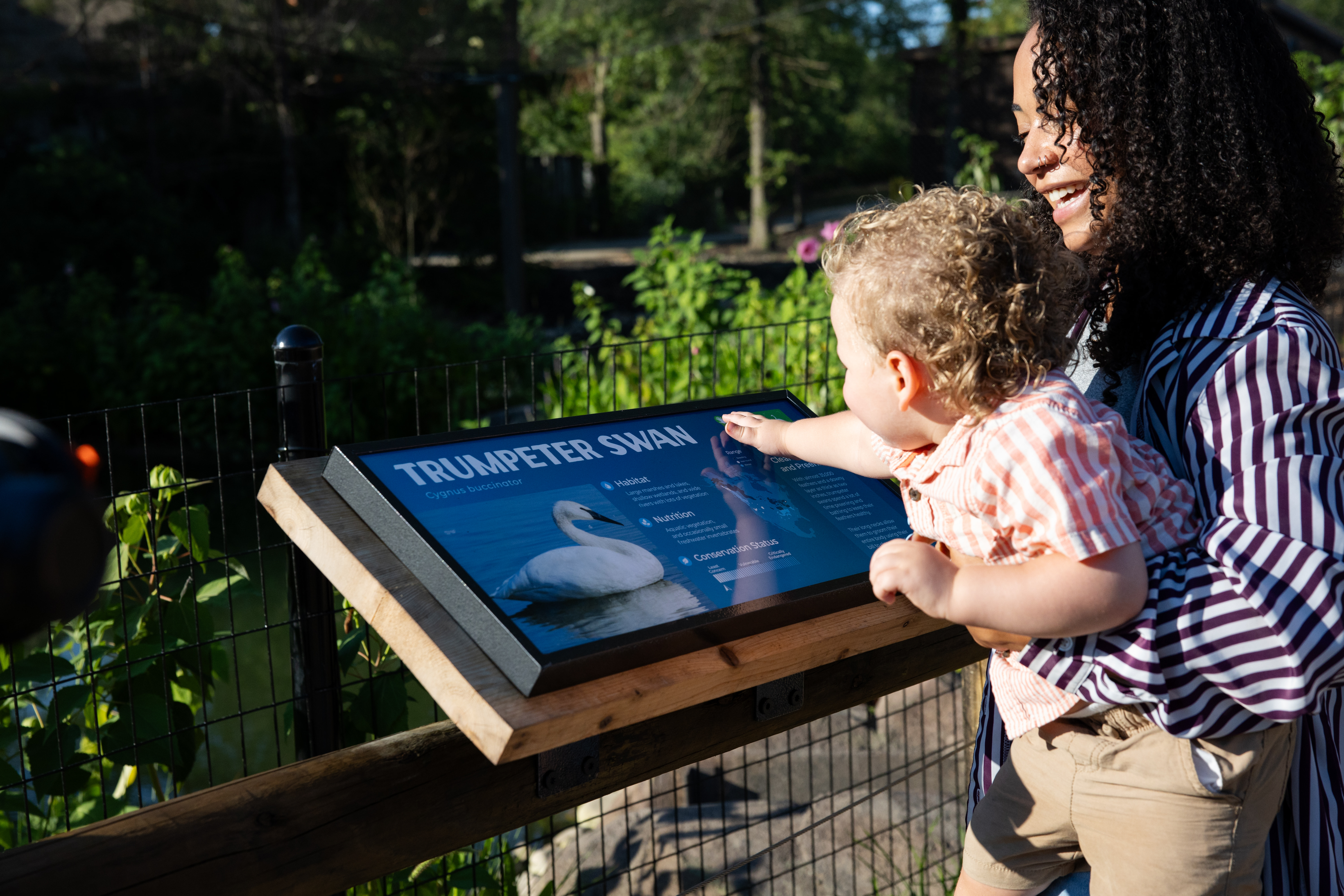 woman holding baby, looking at sign