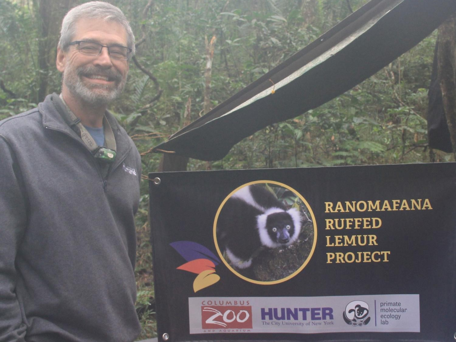 veterinarian posing next to sign