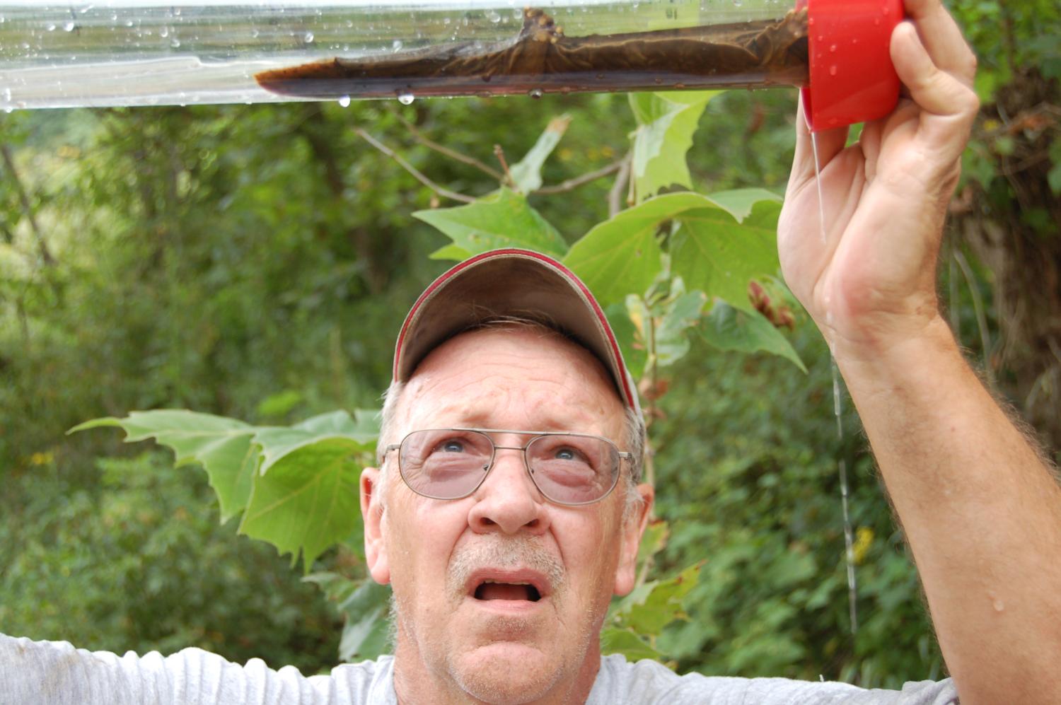 man holding hellbender in study tube