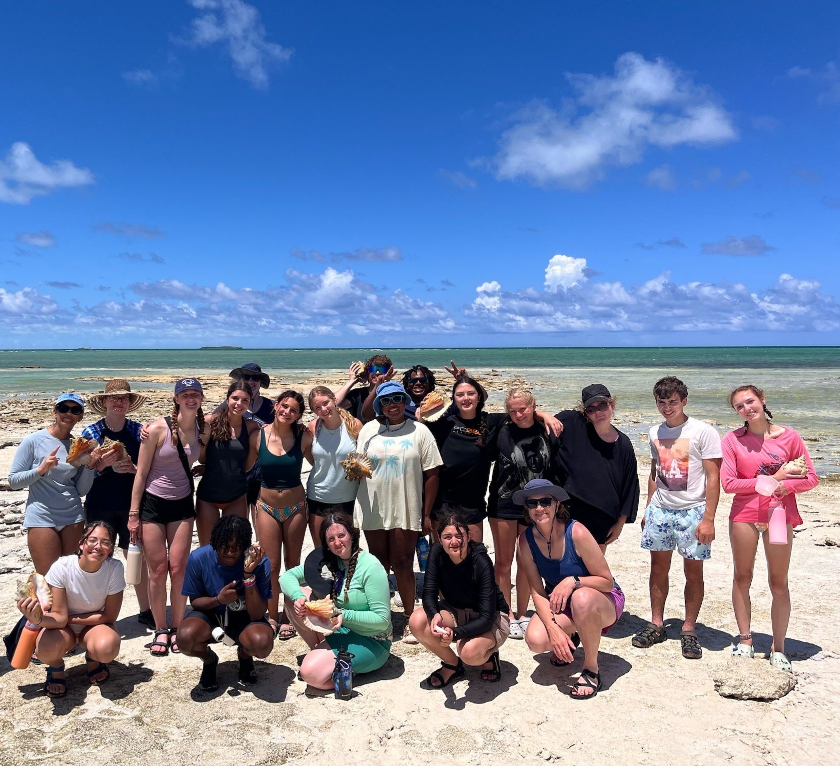 students posing in front of ocean