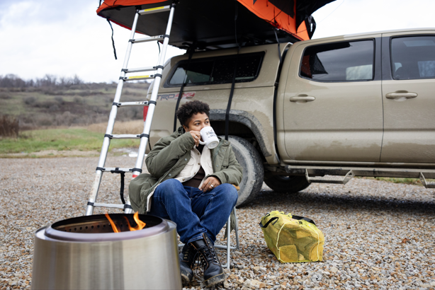 primitive camping at The Wilds, camper drinking coffee in front of truck tent