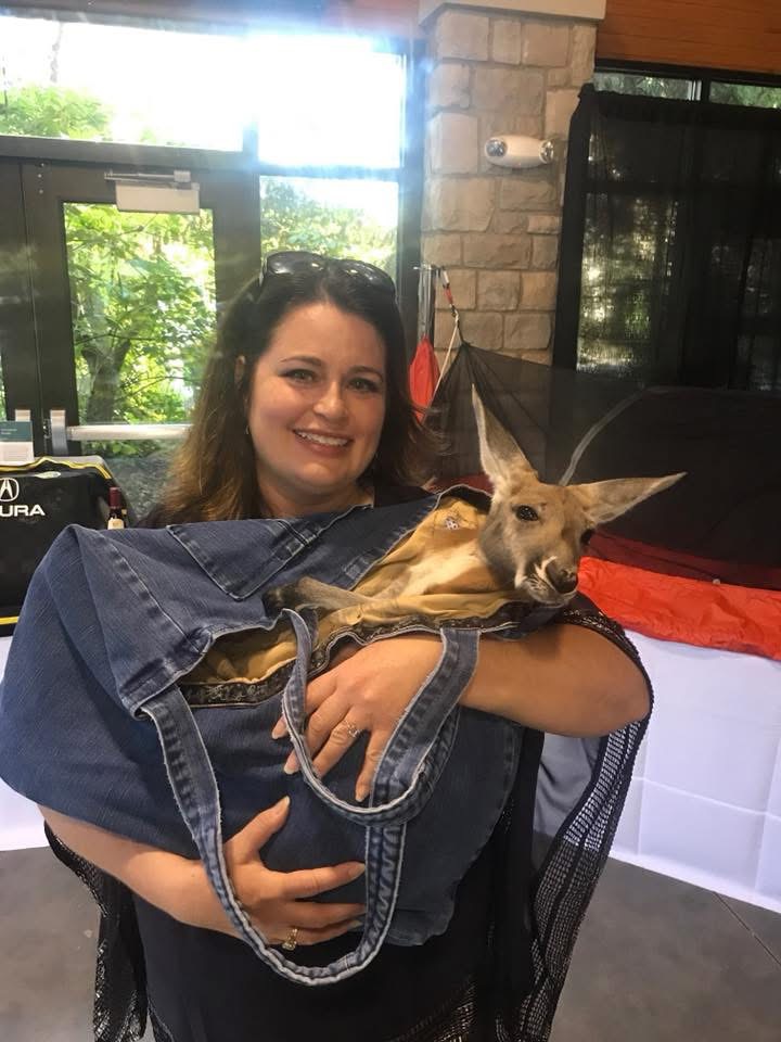 woman holding kangaroo in bag