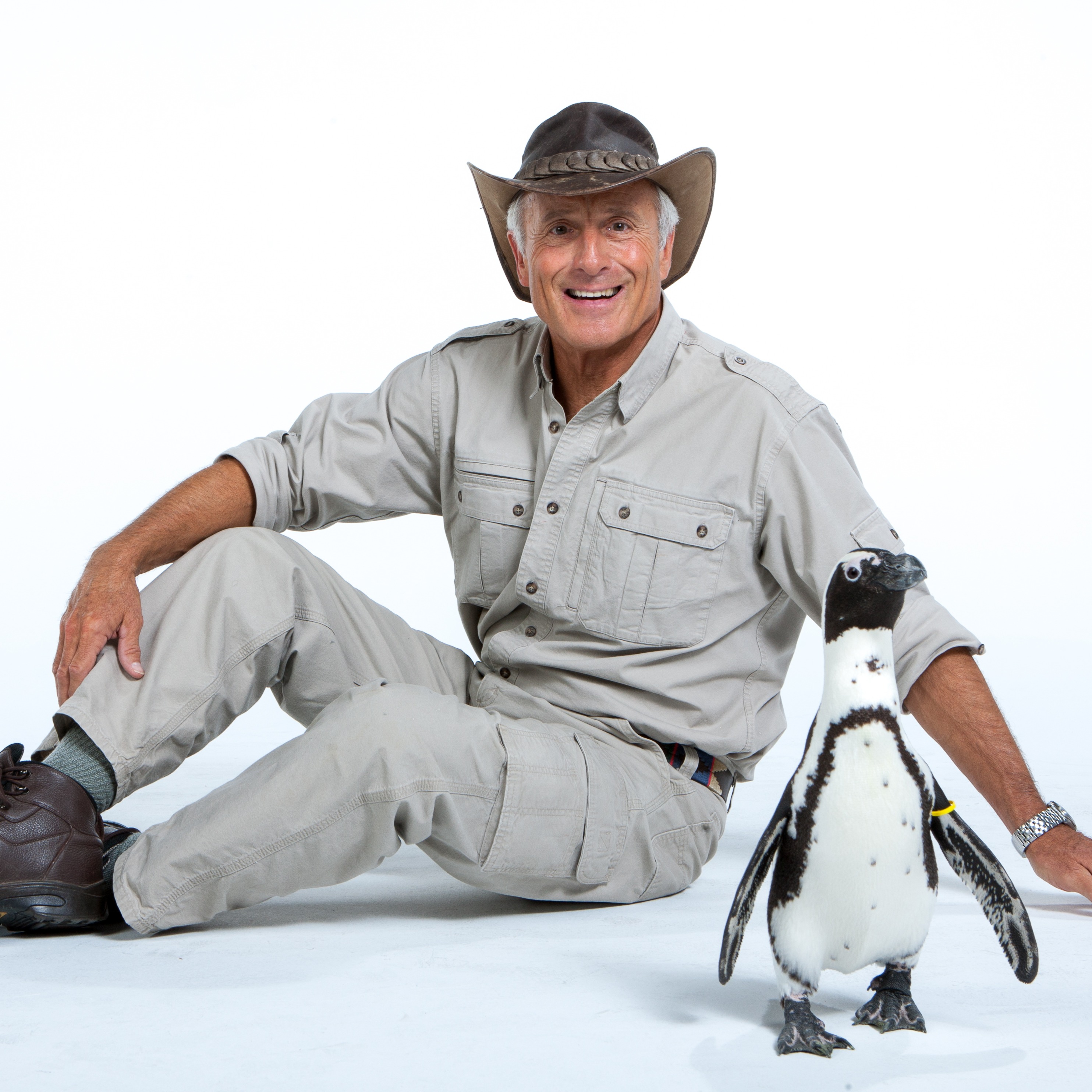 Jack Hanna posing with penguin in foreground