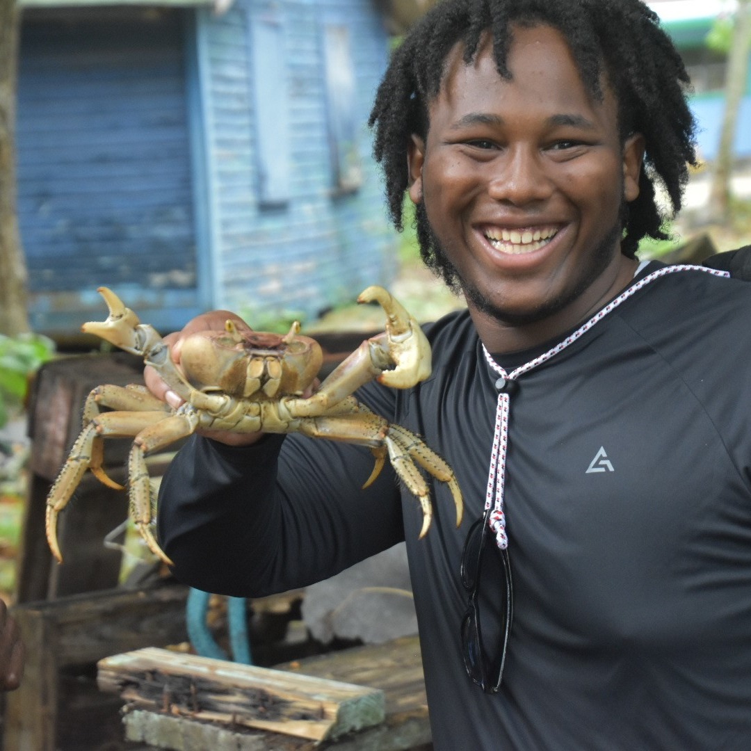 teen holding crab in beachy setting