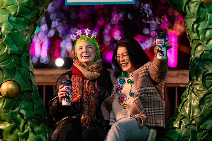zoo guests holding hot chocolate cups and laughing