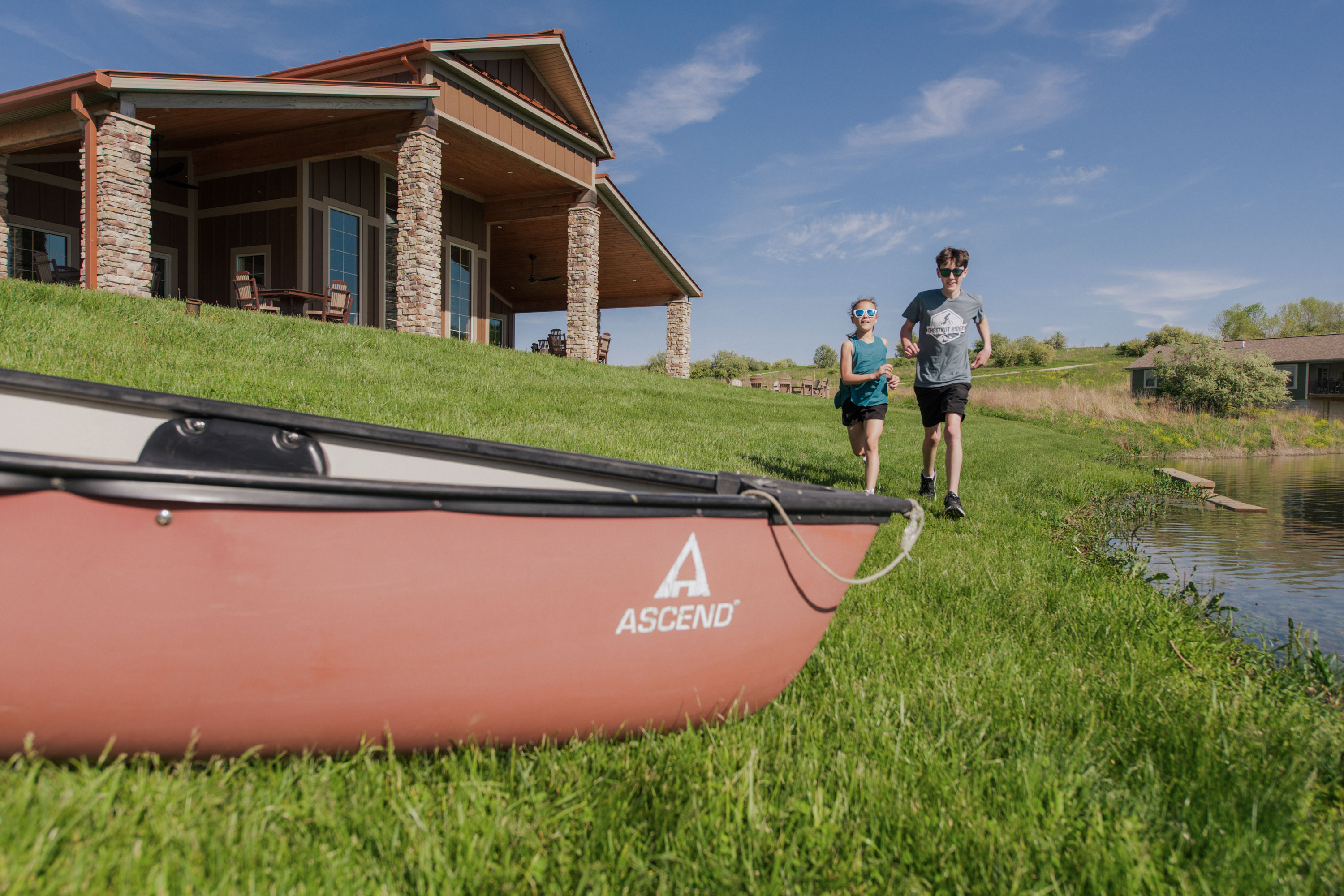 children running towards canoe outside of a lodge at The Wilds
