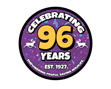 Logo of an purple emblem with confetti, with the words "Celebrating 96 years" with two reindeer silhouettes flanking it