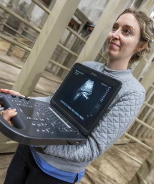 woman holding ultrasound monitor