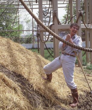 Charlene cleaning the gorilla habitat while smiling at the camera 