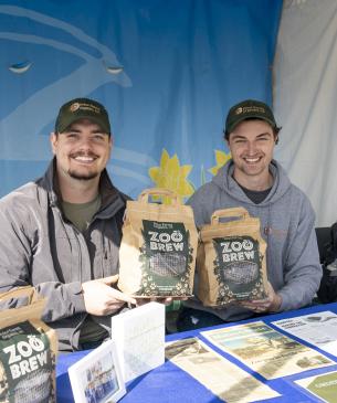 two team members holding bags of compost