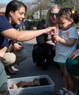 zoo employee giving flower to child