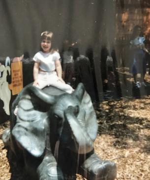 child on bronze statue of elephant
