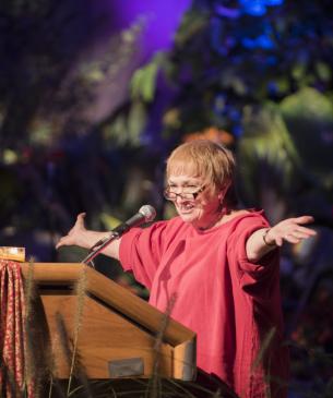 Charlene at a podium smiling at the audience