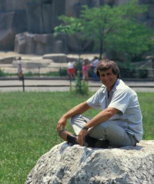 Jack Hanna sitting on a boulder at the Columbus Zoo