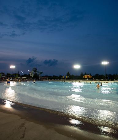 Photo of Zoombezi Bay's tide pool in the evening, with a few spotlights