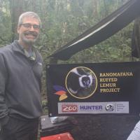 Zoo veterinarian standing next to sign