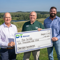 check presentation with three men posing for picture