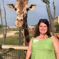 giraffe and woman in green shirt