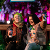 two guests holding hot chocolate and laughing
