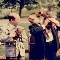 Two men holding wolf cubs