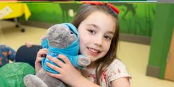 girl holding plush animal at zoo