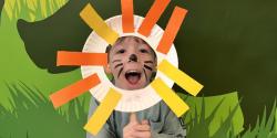 child with craft plate near face