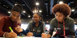 three teens working at a table