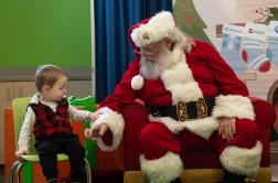 A child inspects Santa's sleeve