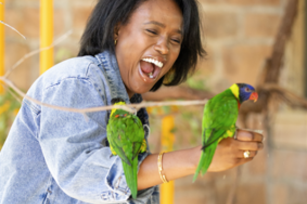 guest with lorikeets perched on her