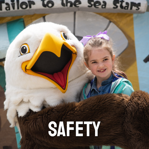 small child smiling near zoo mascot