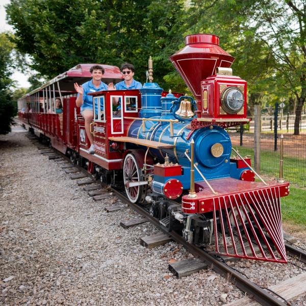 train with employees on top, waving