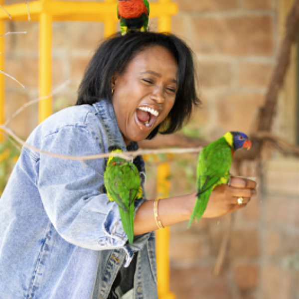 guest with lorikeets perched on her