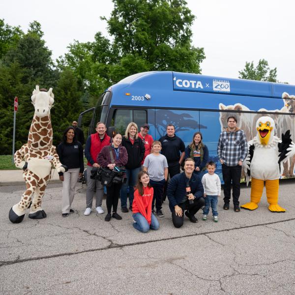 people posing for photo by transit bus