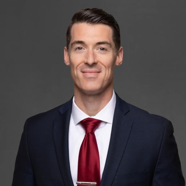 Professional headshot of Christopher Moses wearing a suit