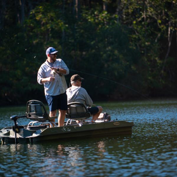 Two people fish from boat on lake at The Wilds