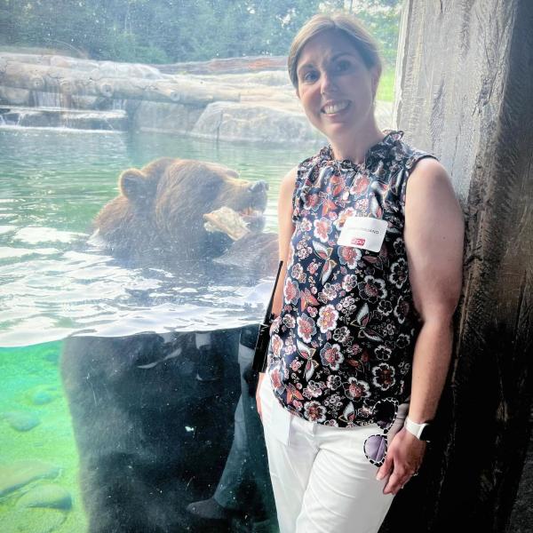 woman posing near bear habitat at zoo