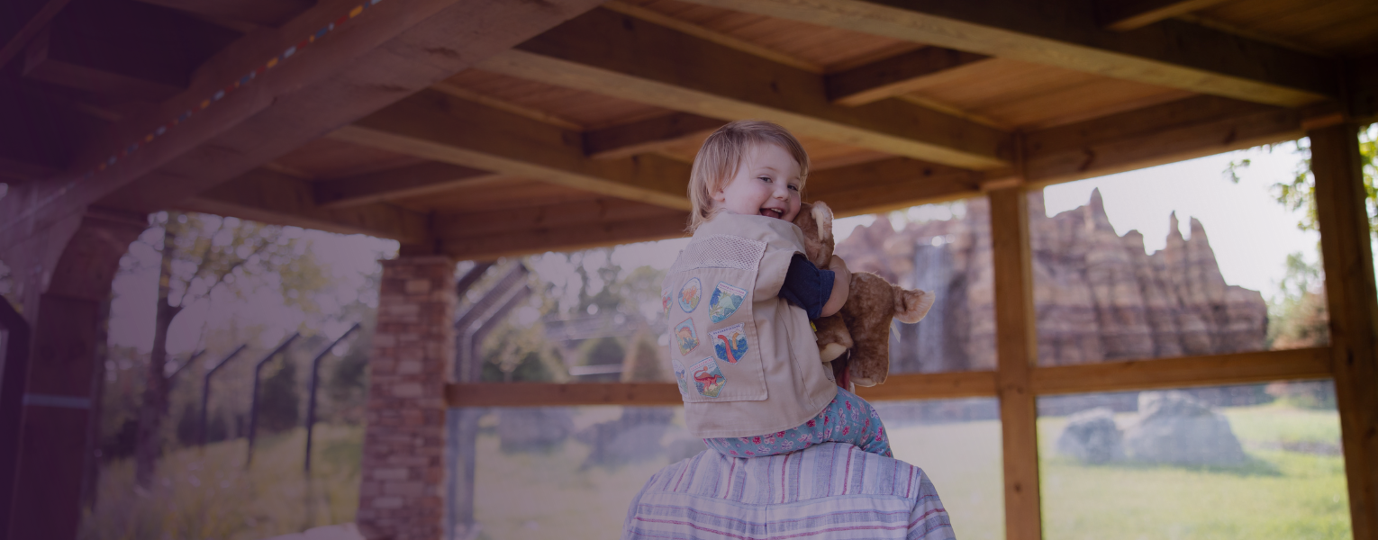 Zoo guests looking into habitat, child smiling at camera